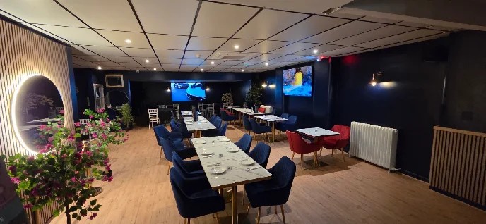 Mystique restaurant interior with big screens and illuminated round mirror